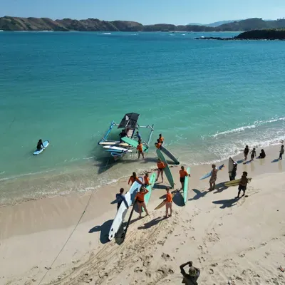 Traditional Indonesian outrigger boat loaded with surfboards on the turquoise water of a Kuta Lombok surf beach