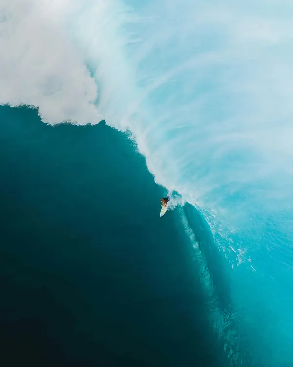 Stunning surf photography shot of surfer carving wave at golden hour in Lombok